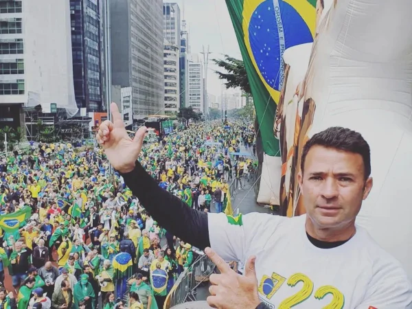 Imagem colorida mostra Mello Araujo fazendo gesto bolsonarista de armas com as mãos - Metrópoles