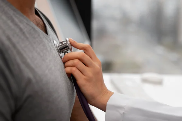 Foto colorida de médico utilizando o estetoscópio em um paciente - Metrópoles.