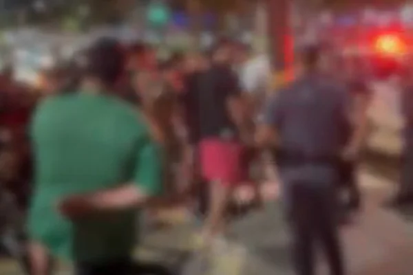 Imagem colorida desfocada de uma confusão com PMs e civis