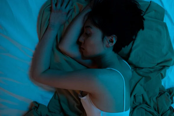 Na foto uma mulher deitada da cama com insônia - acordar às 3h da manhã pode ser desregulação de cortisol - Metrópoles