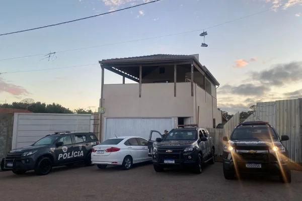 Foto colorida de viaturas da Polícia Militar em endereço onde foi cumprido mandado de busca e apreensão contra grupo de traficantes ligados ao PCC.