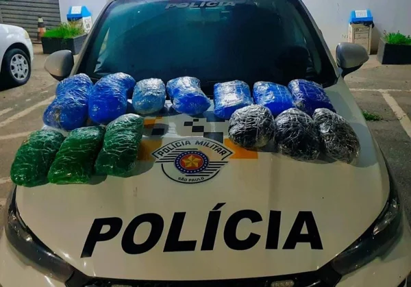 Imagem colorida mostra diversos pacotes de maconha, nas cores azul e verde, em cima do capô de um carro da Polícia Militar (PM); as drogas foram apreendidas com uma mulher, que disse que transportava a maconha de Brasília para Santa Catarina, passando por São Paulo - Metrópoles