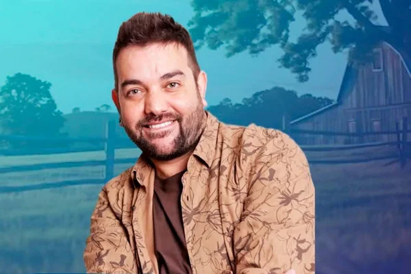 Sander Mecca posa de look marrom e sorridente - Metrópoles