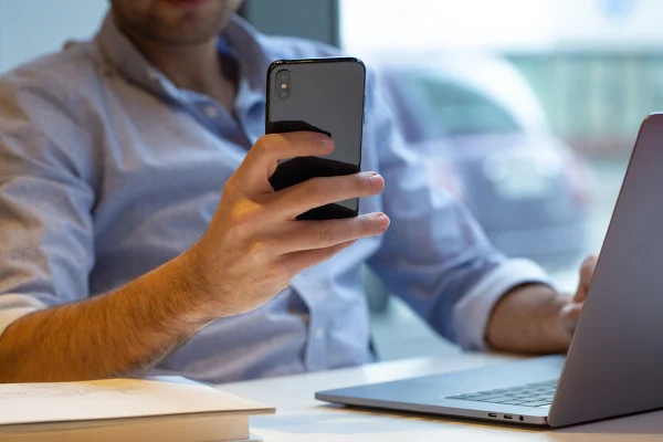 Homem segurando celular - Metrópoles