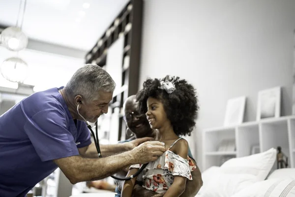 Imagem colorida de médico atendendo crianças