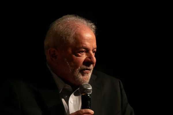 Imagem colorida mostra Luiz Inácio Lula da Silva, presidente eleito, em pé em um palco. Ele usa terno e segura um microfone - Metrópoles