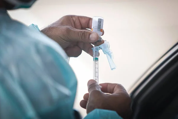 Profissional de saúde segura seringa com vacina com dose contra Covid - Metrópoles