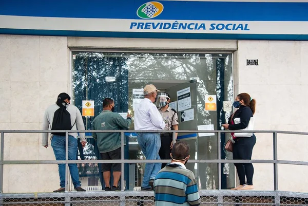 Imagem colorida mostra fila em frente a agência do INSS, que presta serviço para aposentados - Metrópoles