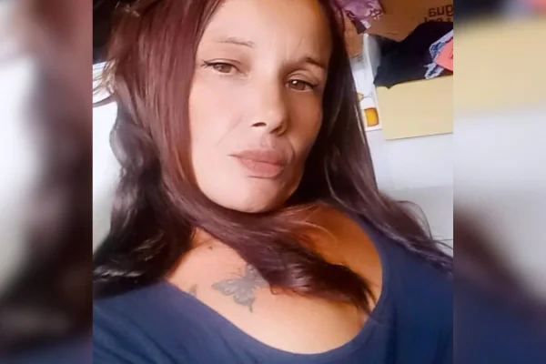 Imagem colorida mostra mulher de pele parda, com cabelos avermelhados e uma tatuagem no colo vestindo uma camiseta preta - Metrópoles