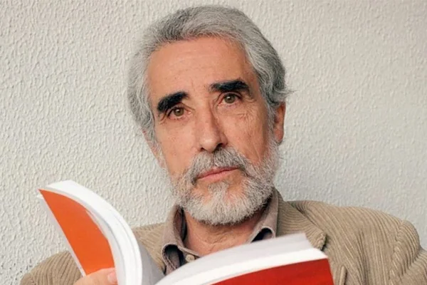 João Barrento em foto colorida. Homem branco, com cabelo e barba grisalha, segura um livro - Metrópoles