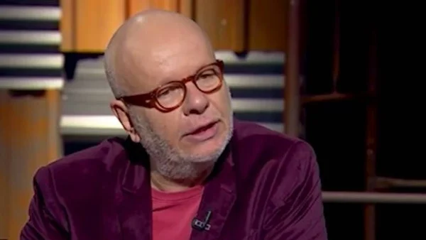 foto colorida de Marcelo Tas de oculos colorido, blusa rosa e blazer vinho falando - metrópoles