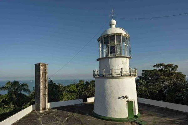 foto colorida de farol e mar ao fundo - metrópoles