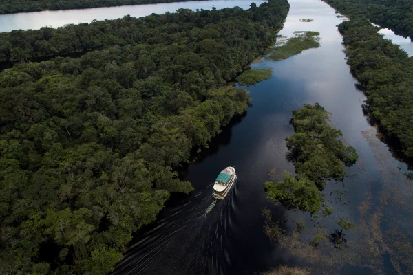 Foto colorida de um barco sobre rio na Amazônia - Metrópoles.