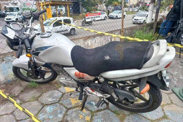 Imagem colorida de moto estacionada com banco sujo de sangue - Metrópoles