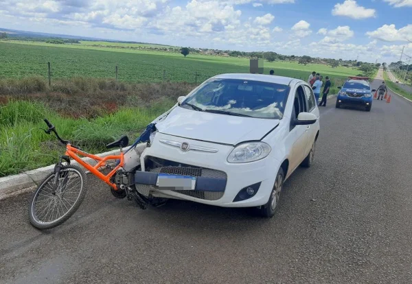 Imagem colorida de acidente com carro branco e bicicleta