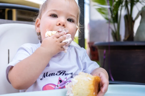 Imagem colorida mostra bebê comendo doce - Metrópoles