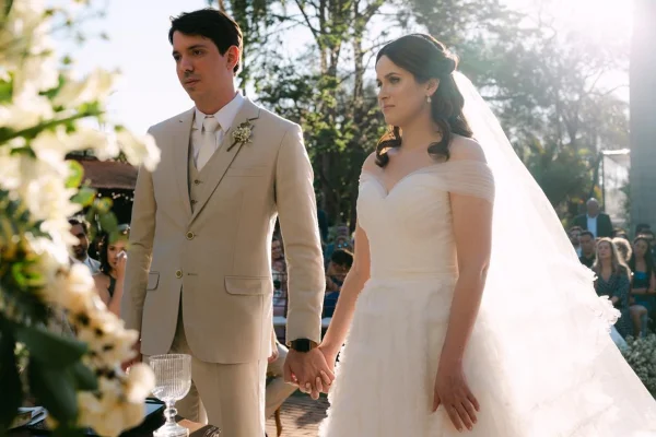 Foto colorida de noivo e noiva no altar durante casamento - Metrópoles.
