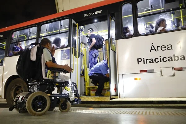 Fotografia colorida mostra cadeirante pegando ônibus em Brasília - Metrópoles