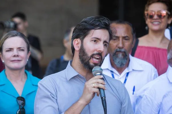Homem com camisa azul segurando microfone