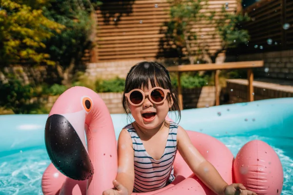 foto colorida criança com óculos de sol no verão