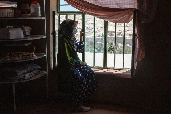 Menina do Afeganistão olha pela janela