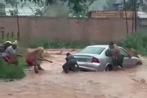 Fotografia colorida de carro sendo resgatado em enxurrada