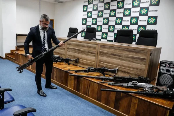 Delegado Marcus Amim, chefe da Polícia Civil, mostra as metralhadoras que foram entregues pelos criminosos