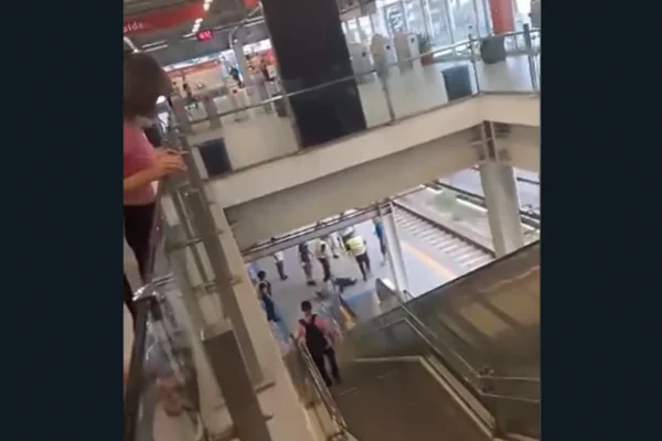 Imagem colorida de um homem sendo espancado por dois homens, enquanto pessoas ao redor tentam separar a agressão - Metrópoles