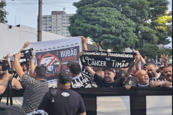Imagens coloridas mostram protesto de torcedores do Corinthians com cartazes, faixas e gritos de guerra em frente à sede do clube