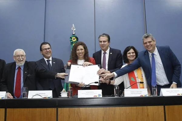 Foto colorida de ministros do governo Lula durante assinatura de portaria sobre mesa de negociações - Metrópoles
