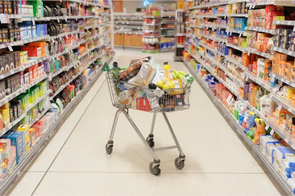 Carrinho de mercado com produtos - alimentos industrializados, supermercados, lista de compras