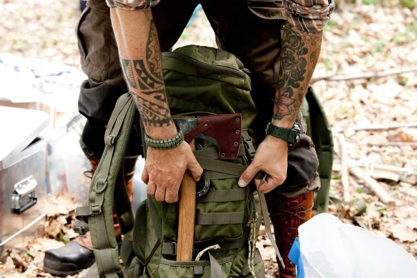 Homem tatuado arrumando a mochila
