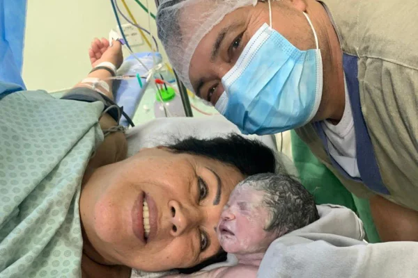 Foto colorida de uma mulher, um homem e um bebê - Metrópoles