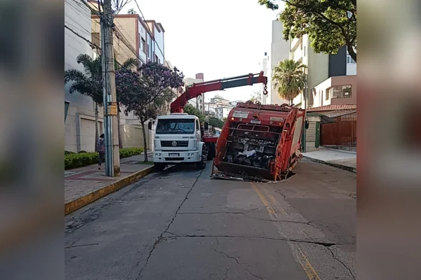 Carro de limpeza sendo içado do buraco em BH