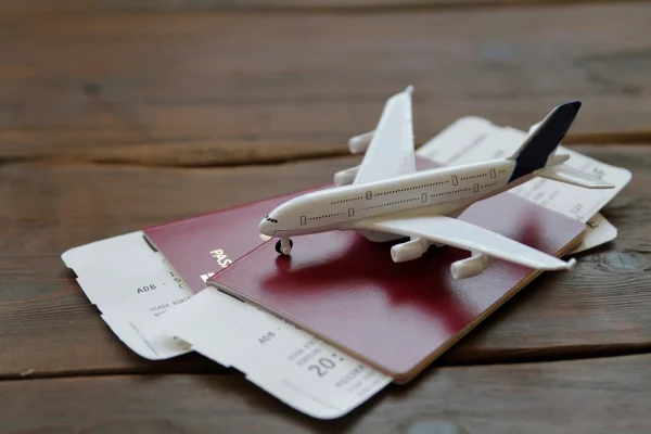 Foto colorida de avião de brinquedo sobre passaportes e cartões de embarque - Metrópoles