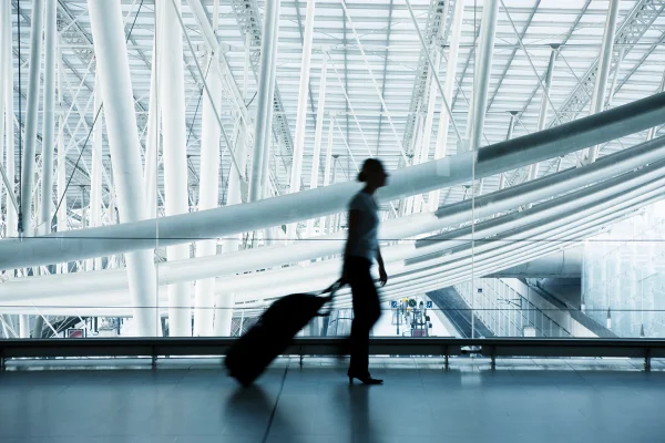 Pessoa levando uma mala no aeroporto, foto colorida