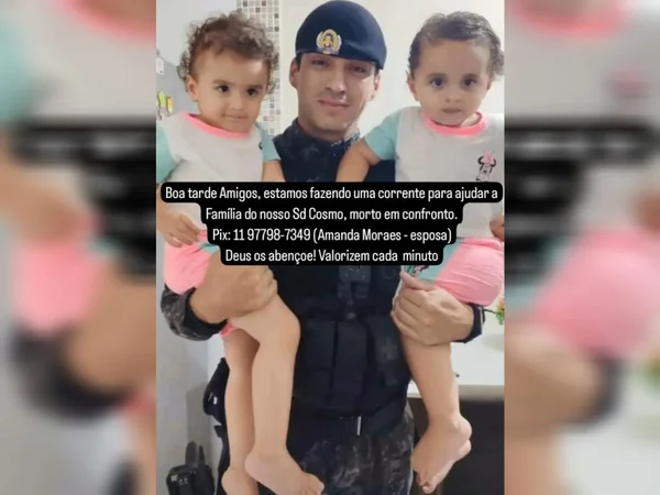 Imagem de policial segurando duas meninas gêmeas nos braços - Metrópoles