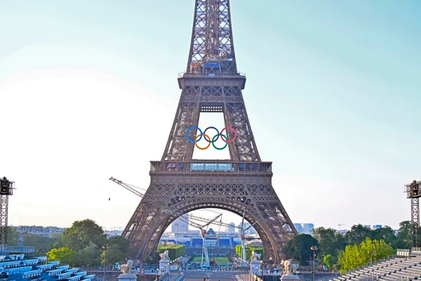 Imagem colorida dos arcos olímpicos na Torre Eiffel - Metrópoles