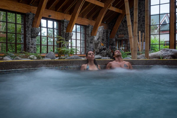 Foto colorida de um casal em uma piscina termal no Chile. Pesquisa indica que estes ambientes foram a origem da vida