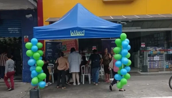 Imagem colorida de tenda da Ambec, associação de aposentados, em calçada em frente a uma farmácia - Metrópoles