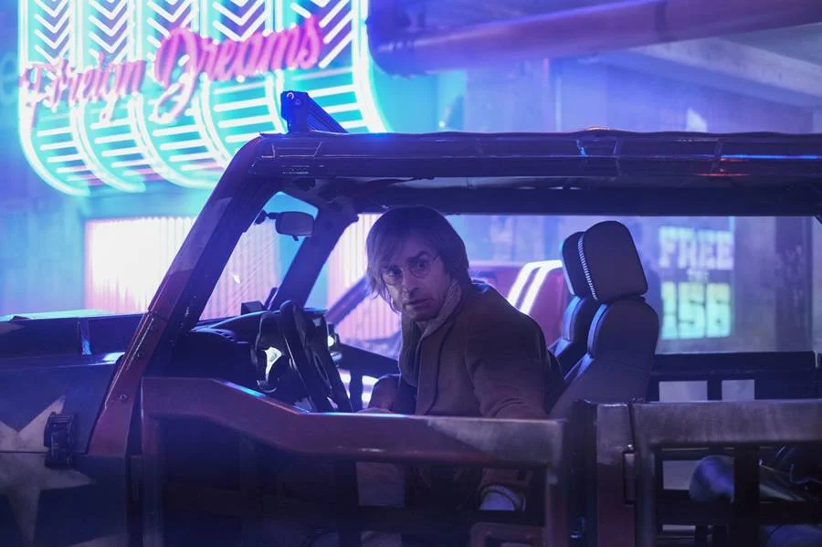 Duck Teddington (Justin Theroux), outro cirurgião excêntrico atuante em uma Berlim futurista Duck Teddington (Justin Theroux), outro cirurgião excêntrico atuante em uma Berlim futurista