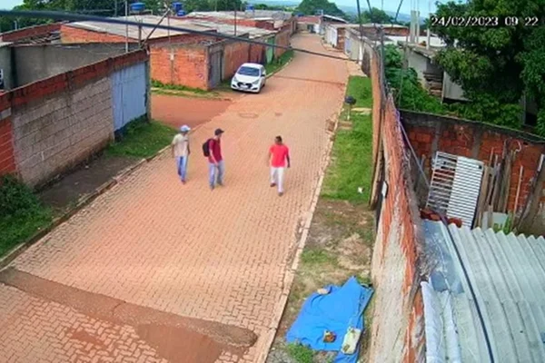 Homens andando em rua de casas