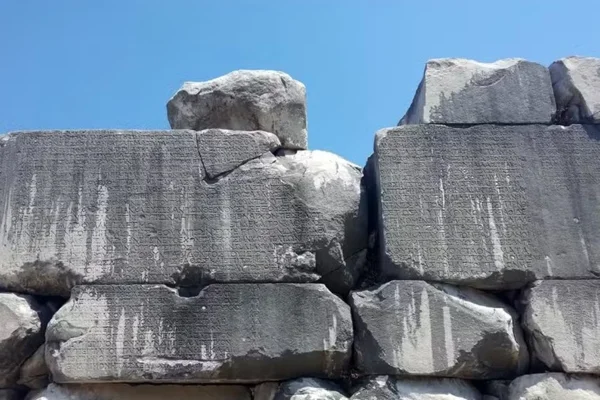 Imagem mostra pedras grandes com escritos esculpidos - Metrópoles