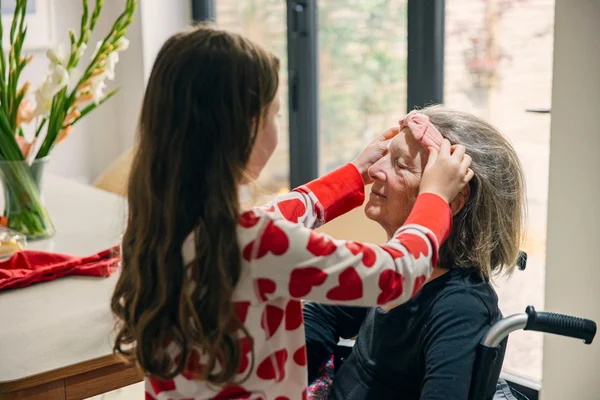 Foto mostra criança colocando tiara na cabeça de idosa com dor crônica - Metrópoles