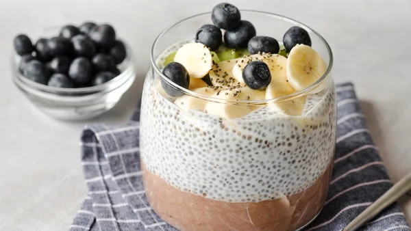 Foto colorida de sobremesa preparada com chia, banana e mirtilos