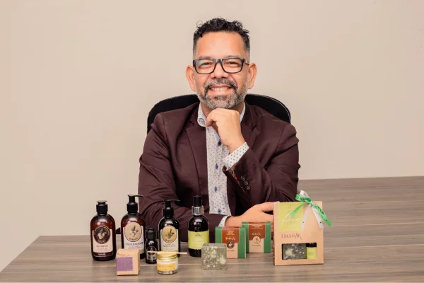 foto colorida de um homem sentado e na mesa com produtos - metrópoles