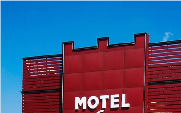 Fachada de prédio vermelho com letras que formam a palavra motel - Metrópoles