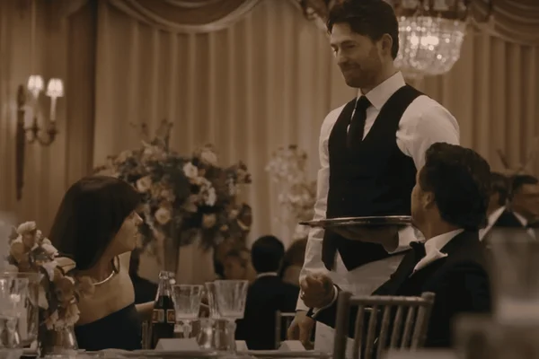 Imagem colorida - Dakota Johnson e Pedro Pascal (sentados) olham para Chris Evans (em pé) em Materialist