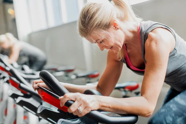 Foto de mulher se exercitando em bicicleta ergométrica na academia - spinning - Metrópoles