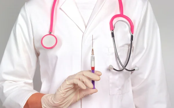médico segurando seringa